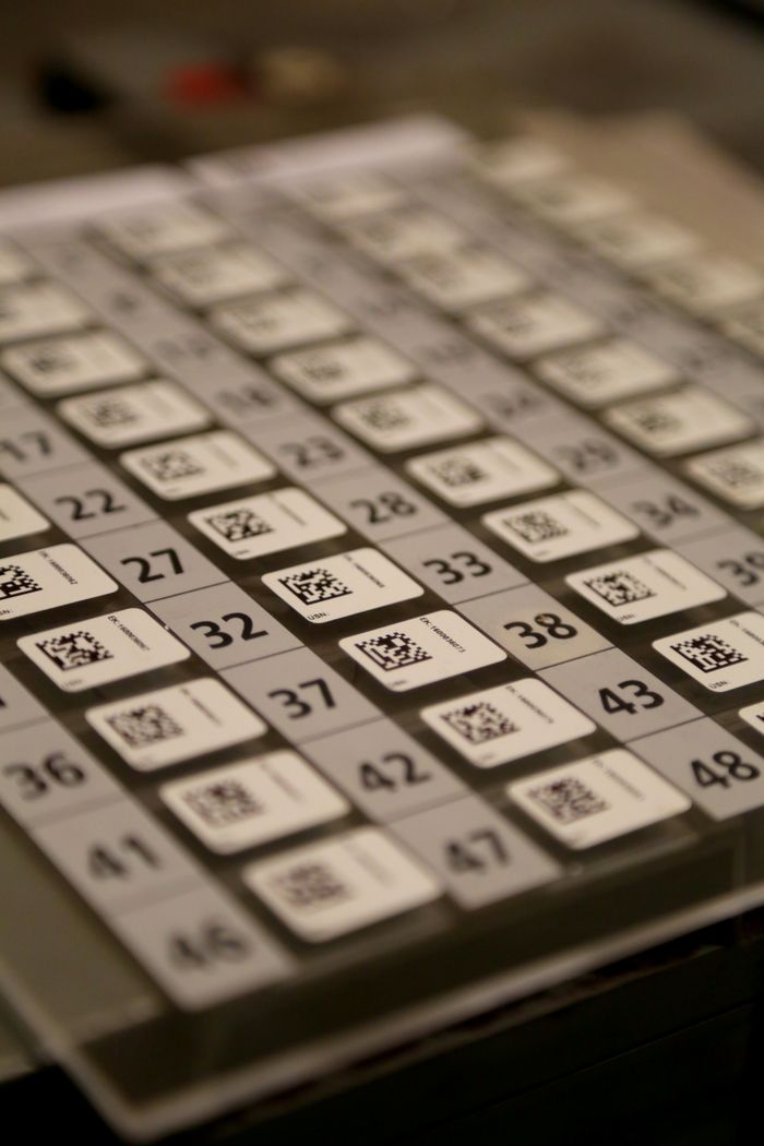 Detailed view of a multiplication table with QR codes on a calculator, showcasing numbers and technology.