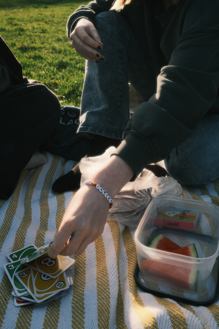 A relaxing picnic with card game on a sunny day with friends.