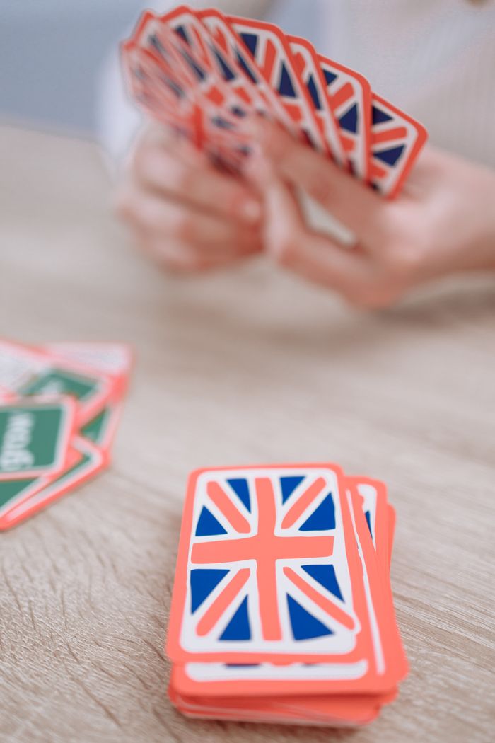 Services Close-up of hands holding British-themed playing cards.